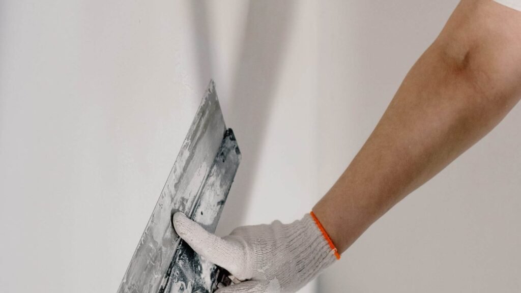 Crop man preparing wall for painting